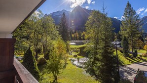 A mountain landscape with a clear sky, trees, and a building in the distance. - IFA Alpenhof Wildental Hotel Kleinwalsertal (Mittelberg)