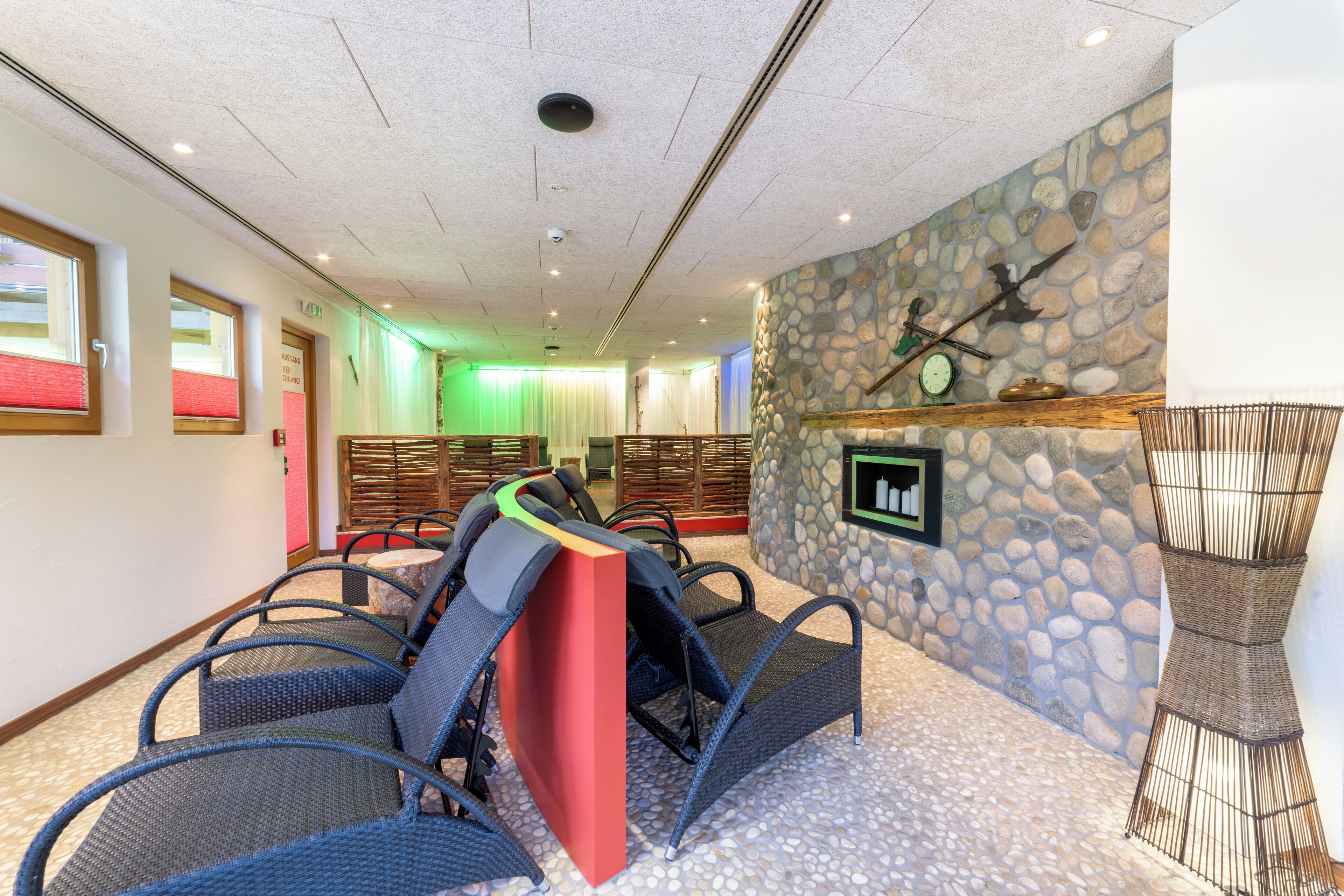 A spa area with wicker chairs, a stone wall, and a reception desk.