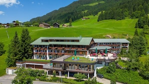 A hotel with a green roof, multiple balconies, and a pool area. - IFA Alpenhof Wildental Hotel Kleinwalsertal (Mittelberg)