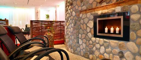 A spa area with stone walls, a clock, and a wall-mounted TV.