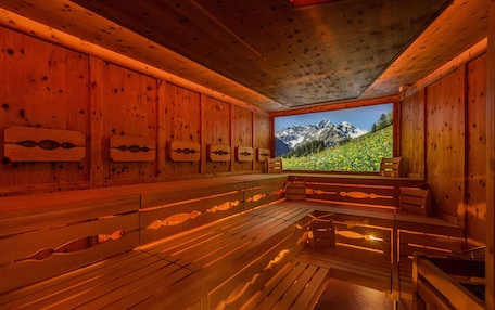 A sauna with wooden benches and a view of a mountain landscape.