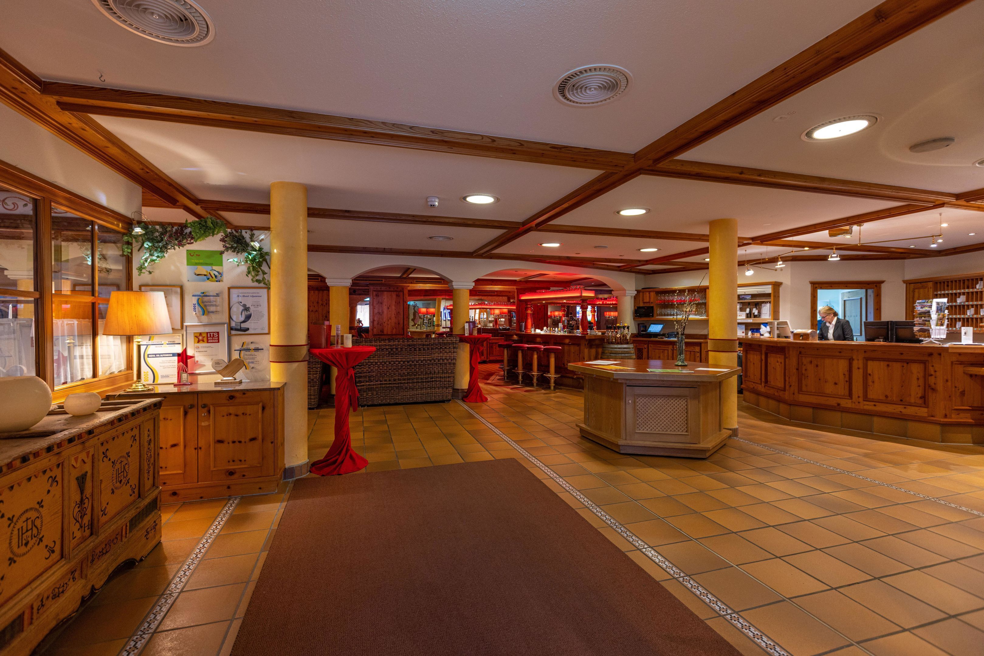 A spacious lobby with wooden beams, a reception desk, and a bar area.