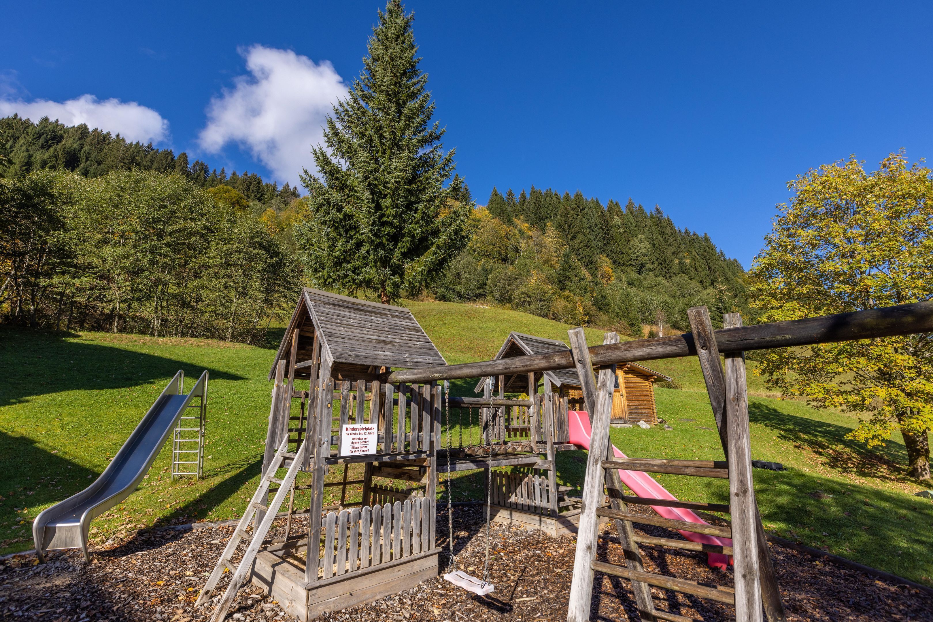 A playground with a slide, swing set, and climbing structures.