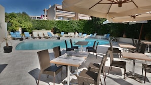 A poolside area with lounge chairs, tables, and umbrellas. - Hôtel de la Mer (Vallauris)