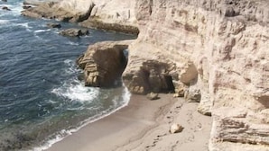 A coastal landscape with cliffs and a beach.