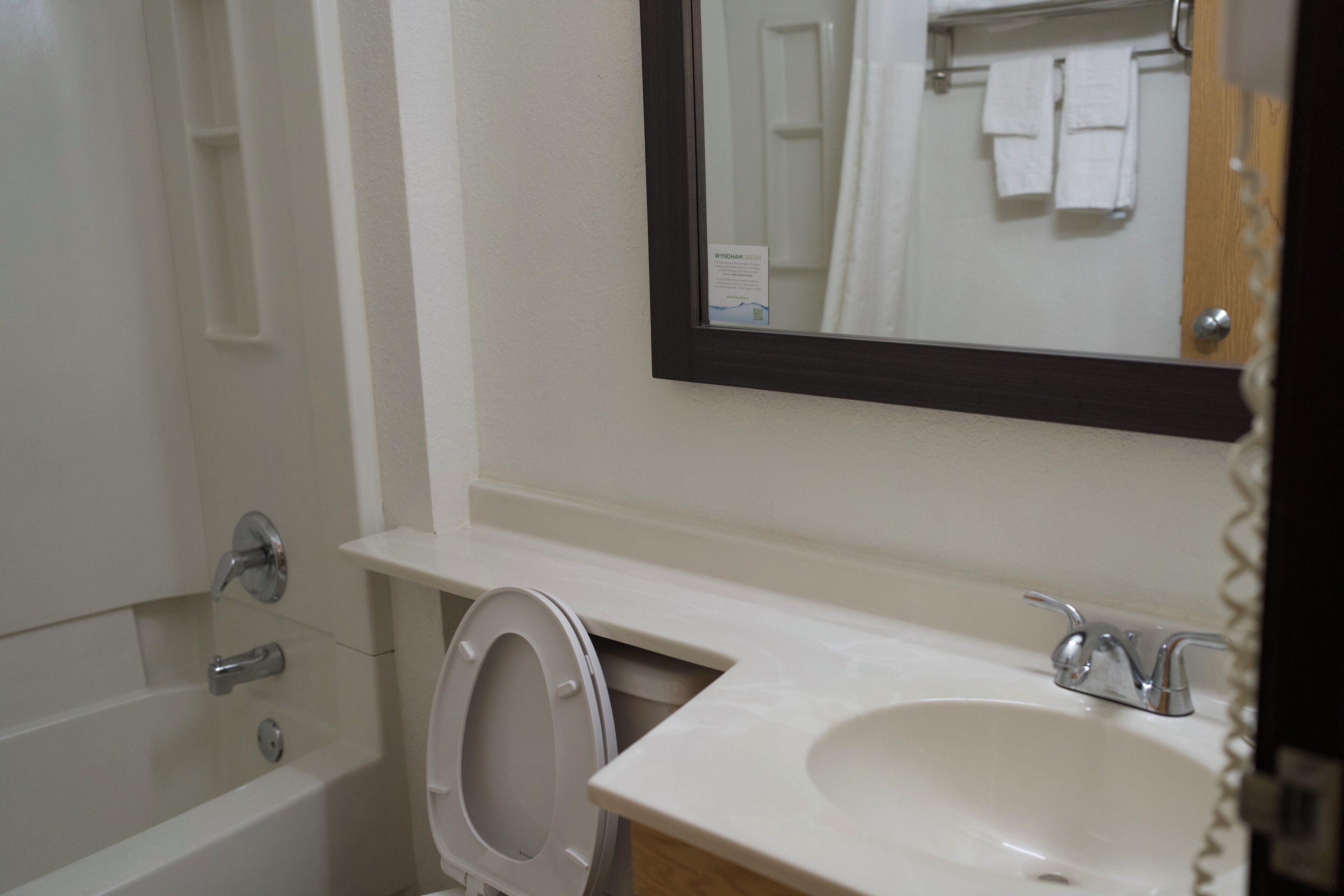 A bathroom with a bathtub, toilet, sink, and a mirror.