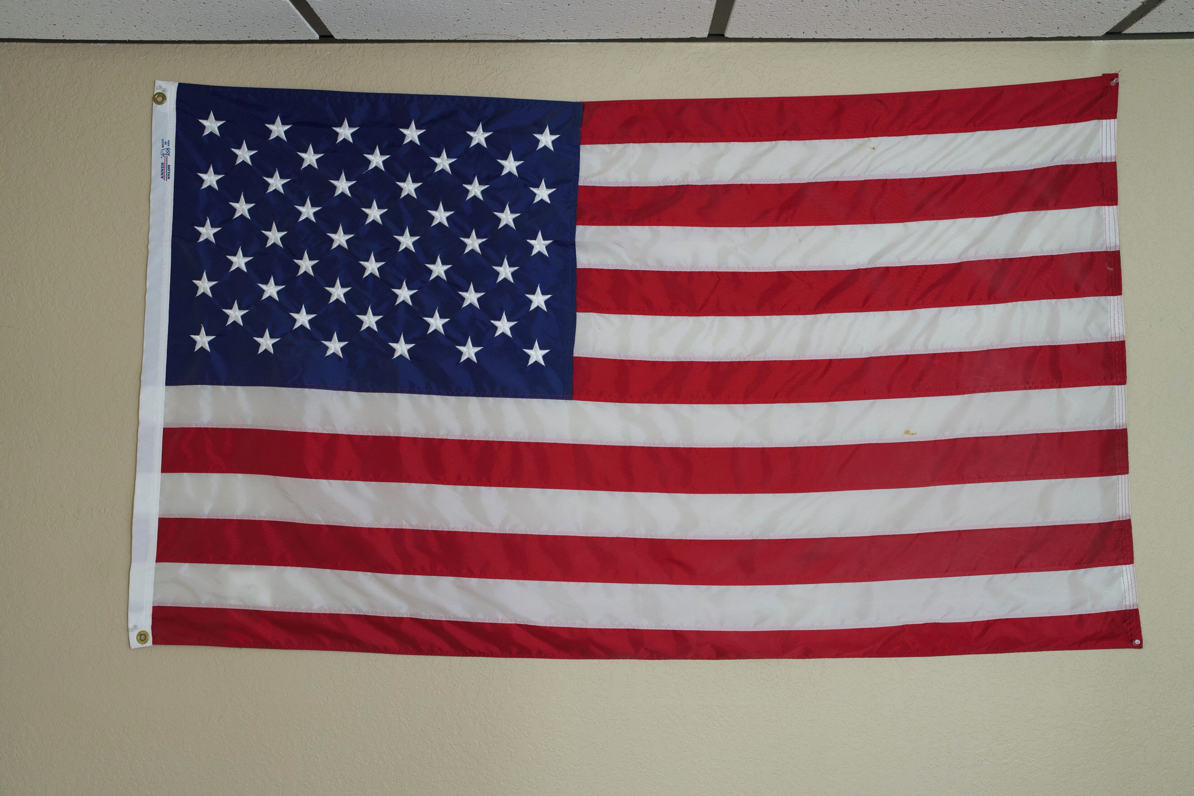 A large American flag hanging on a wall.