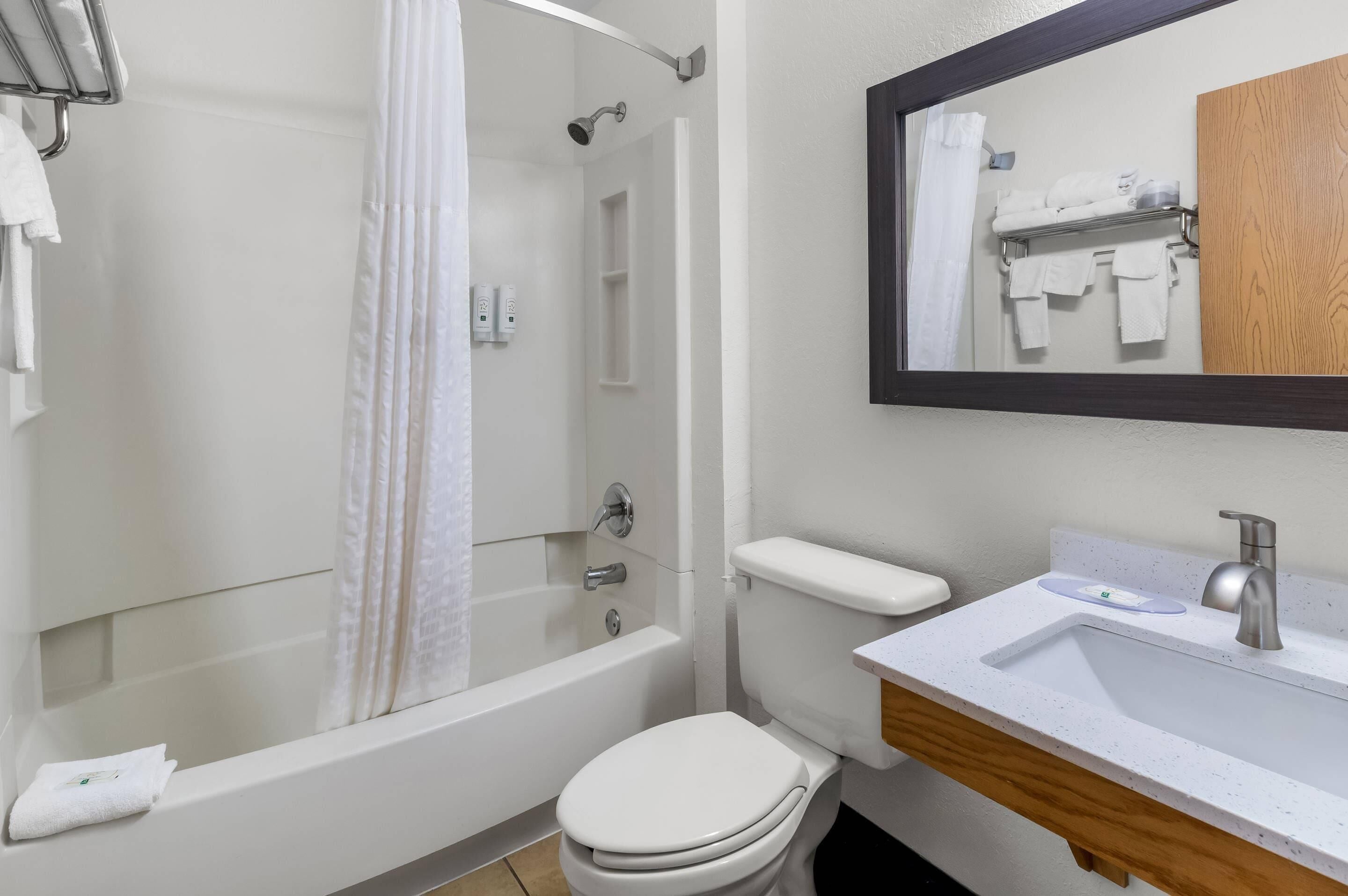 A modern bathroom with a bathtub, toilet, and sink.