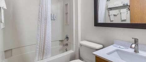 A modern bathroom with a bathtub, toilet, and sink.