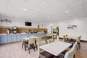 Un restaurante con mostrador, asientos y televisor.
