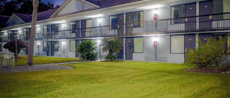A two-story motel with a flat roof, large windows, and a well-maintained lawn.