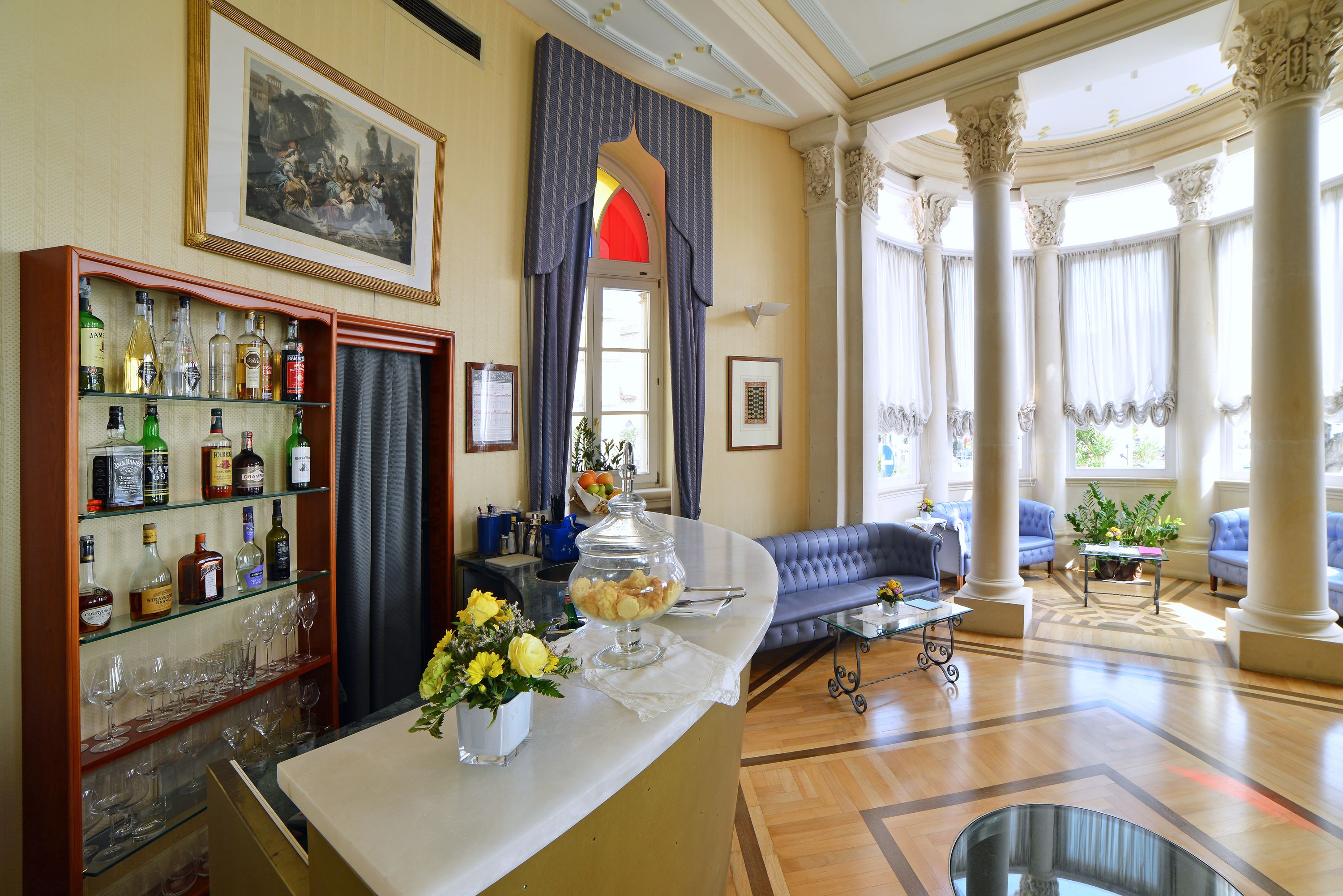 Eine stilvolle Lobby mit Barbereich, Sitzgelegenheiten und einem großen Fenster, das für natürliches Licht sorgt.