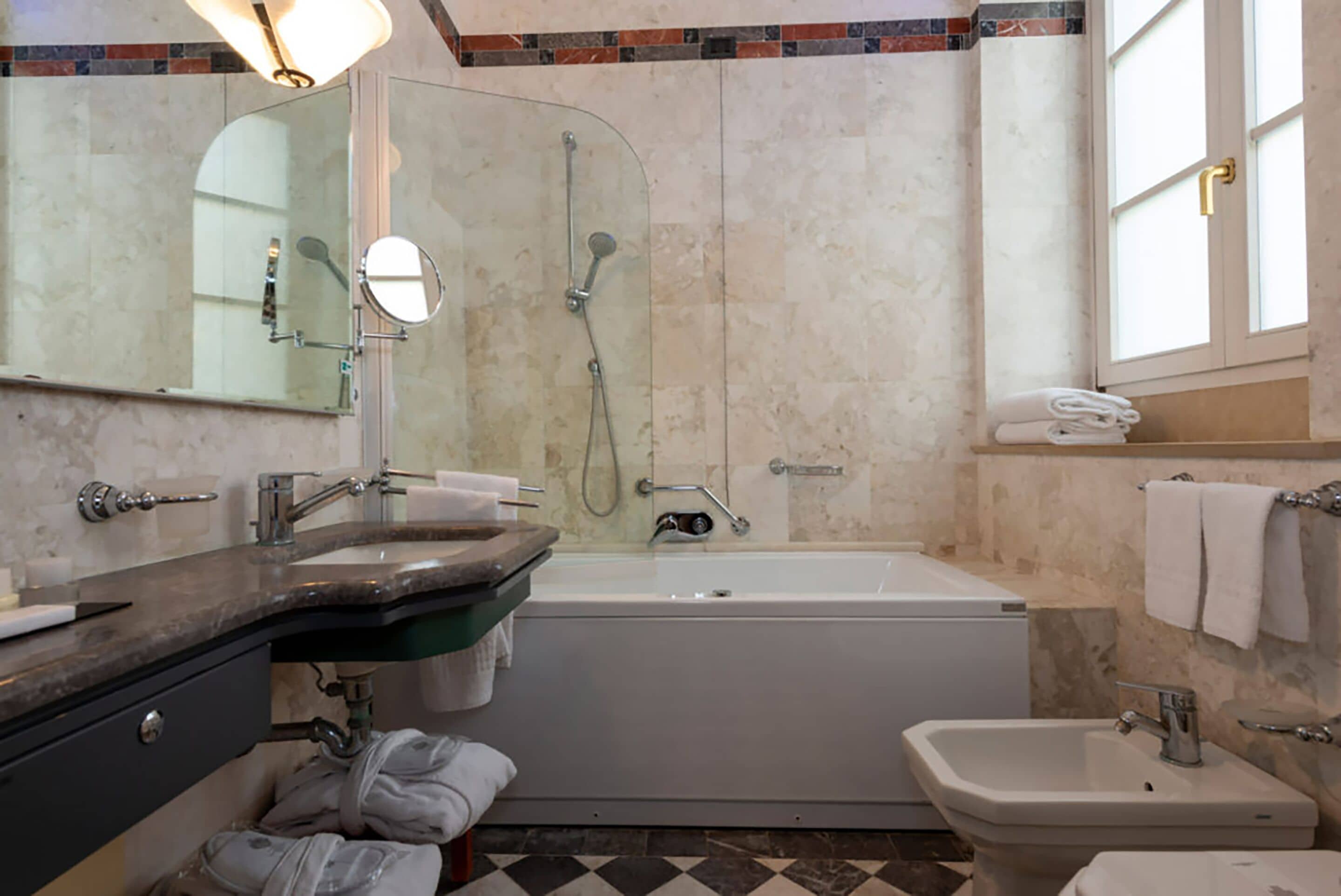 A modern bathroom with a bathtub, a sink, and a mirror.