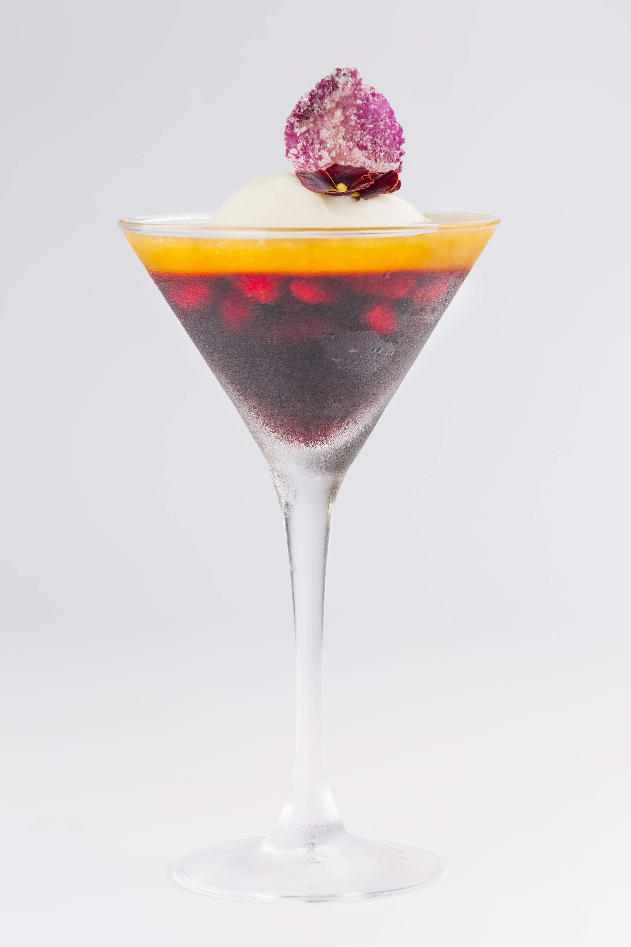 A layered dessert in a martini glass.