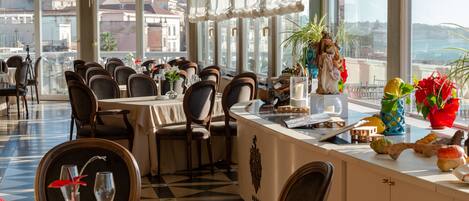 A restaurant with a checkered floor, multiple tables, chairs, and a view of buildings through large windows.