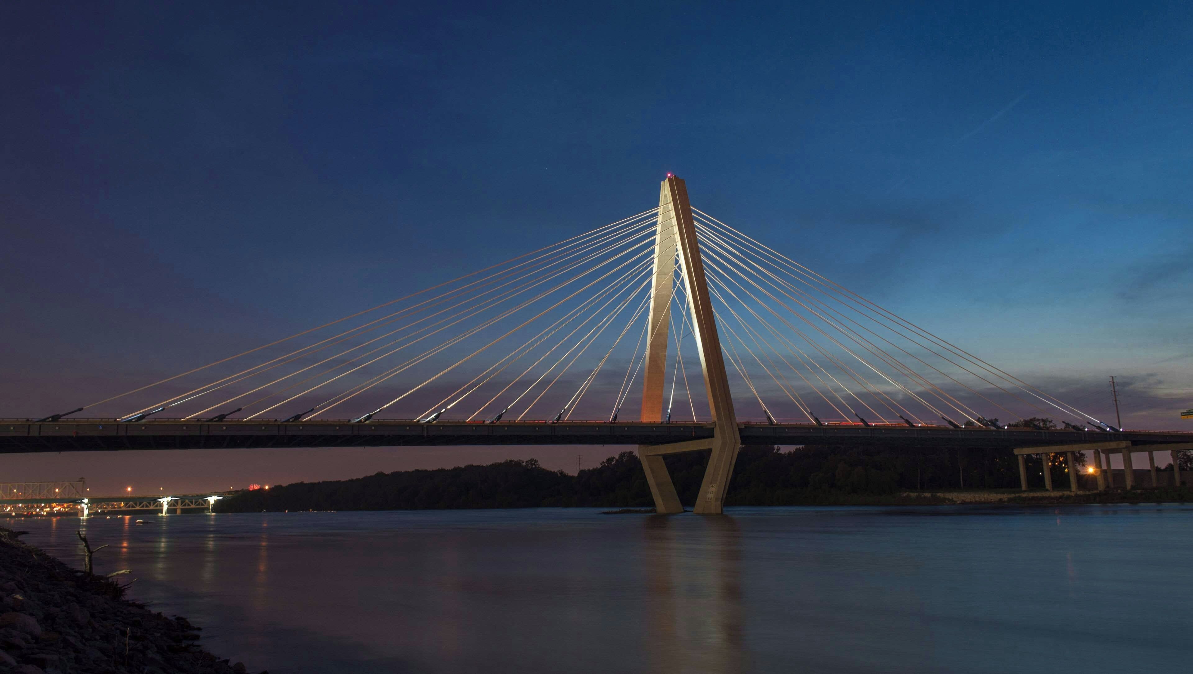 Un puente atirantado al atardecer, con una vista despejada de la estructura y del agua debajo.