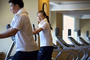 A gym with treadmills and a clock on the wall.