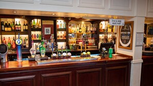 A bar area with a variety of liquor bottles, a beer tap, and a food & drink order point sign. - Bridge Inn by Greene King Inns (Bristol)