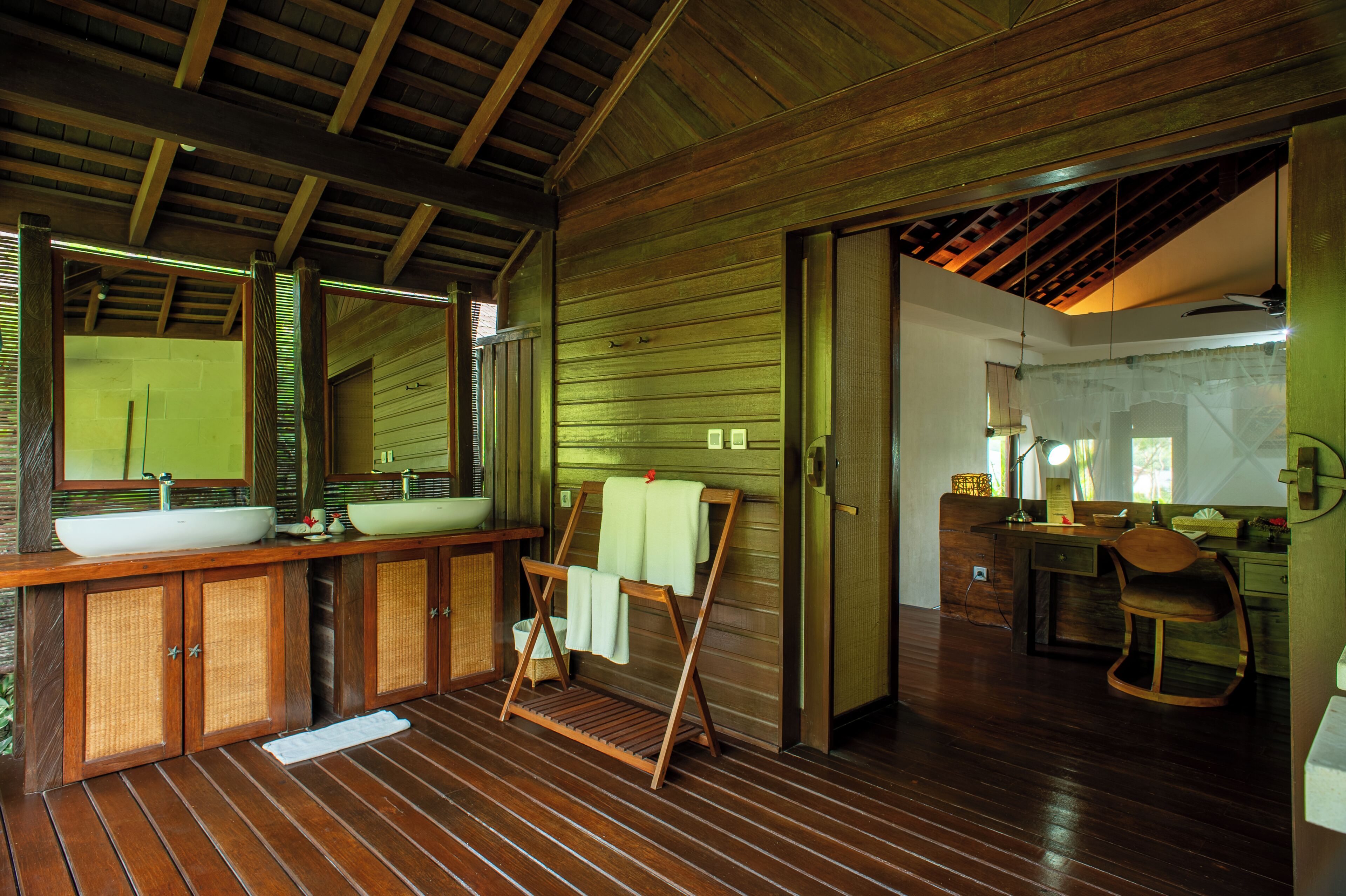 A wooden interior with a large sink, mirror, and wooden cabinets.