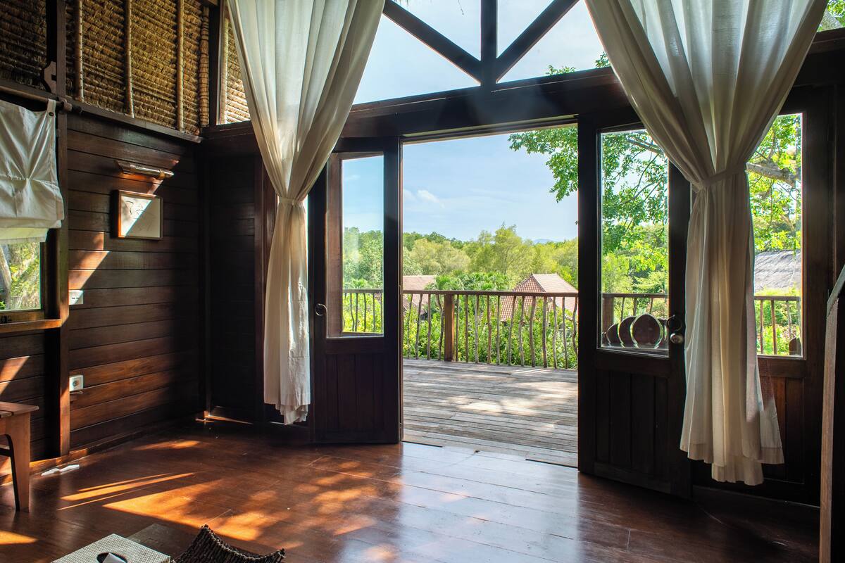 Interior de madera con vista a una terraza y zona exterior.