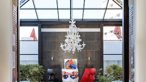 An entrance with a modern chandelier, a glass ceiling, and a brick archway. - New Hotel of Marseille (Marseille)