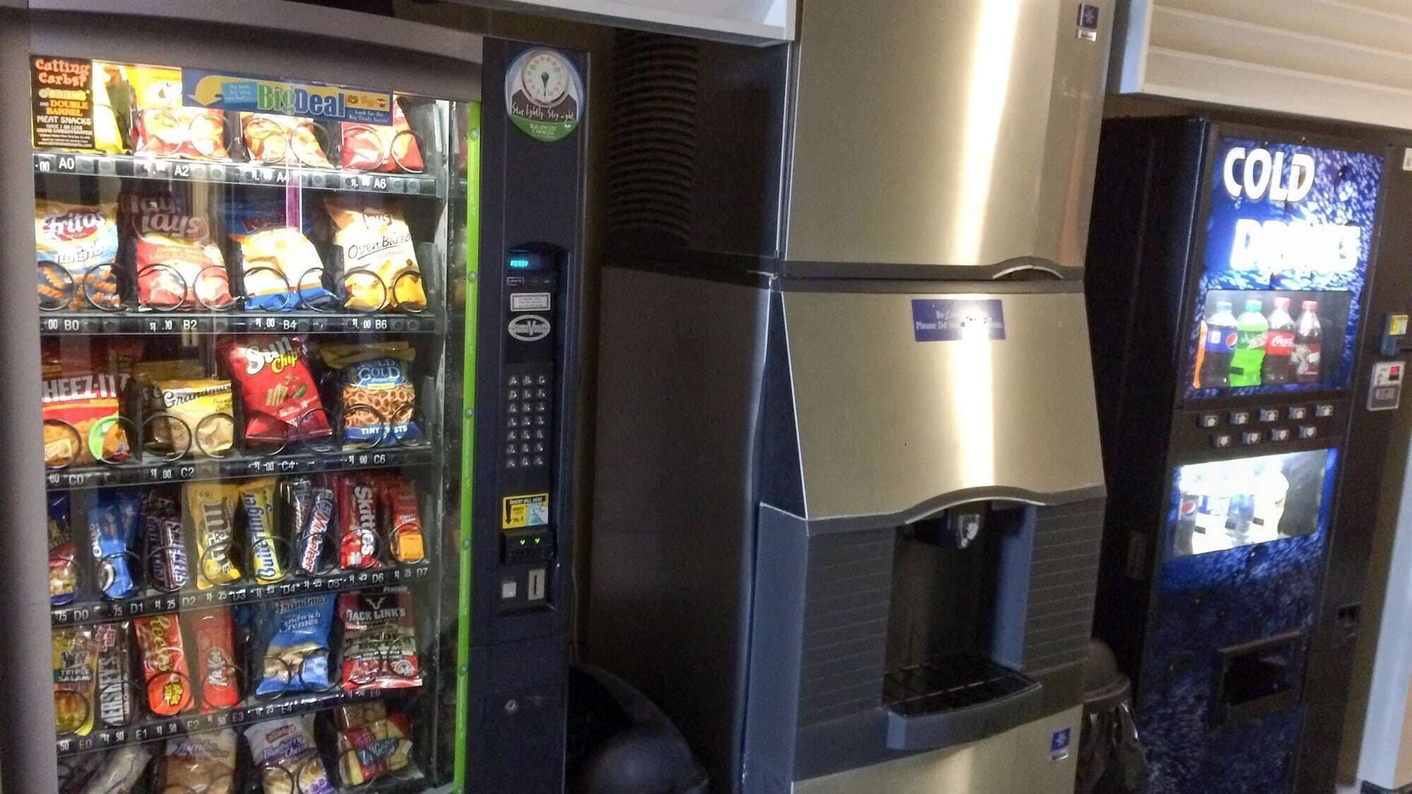Máquina expendedora con aperitivos y un dispensador de bebidas frías.