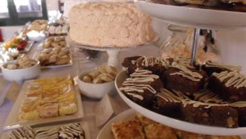 Un bufé de postres con varios pasteles y repostería.