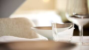 A table with a clear glass, a white bowl, and a silver pitcher.