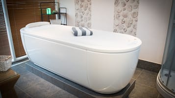 Relax in a spacious bathroom with a bathtub and stylish storage.