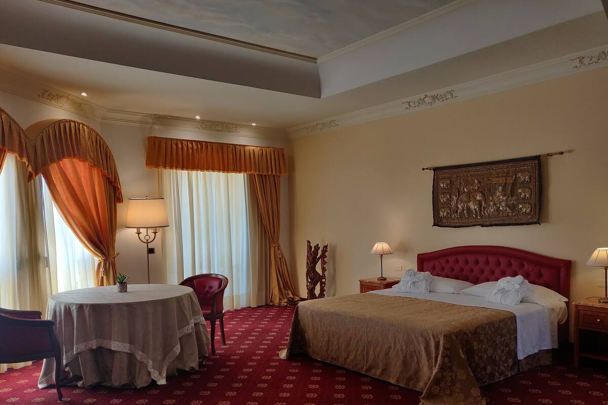 Ein Hotelzimmer mit einem großen Bett, einem runden Tisch und zwei Stühlen.