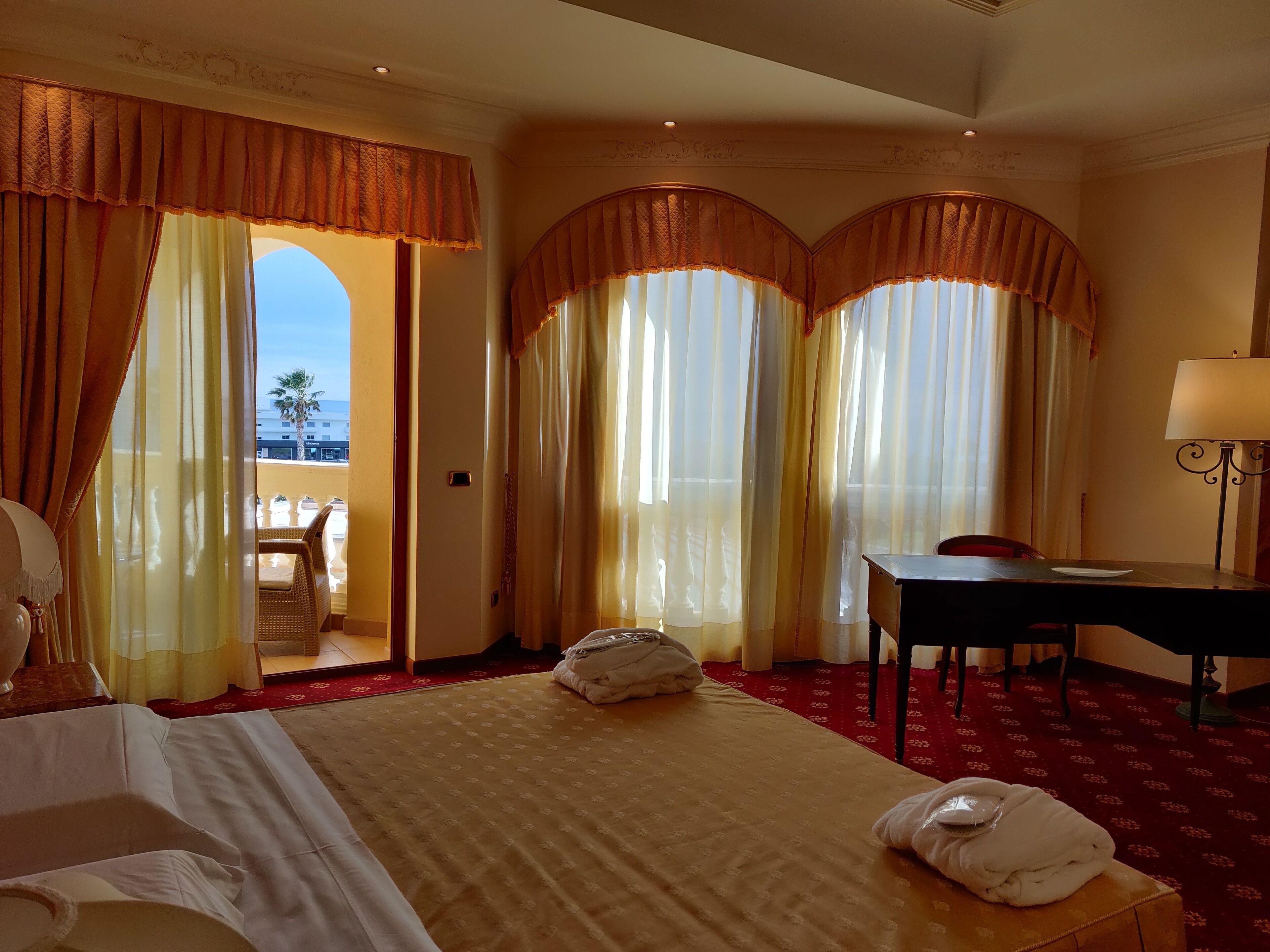 Une chambre d’hôtel avec un grand lit, un bureau et une vue sur l’extérieur.