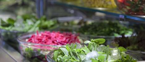 A salad bar with various fresh greens and vegetables.