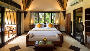 Un dormitorio amplio con una cama grande, un banco de madera y una mesa con fruta.