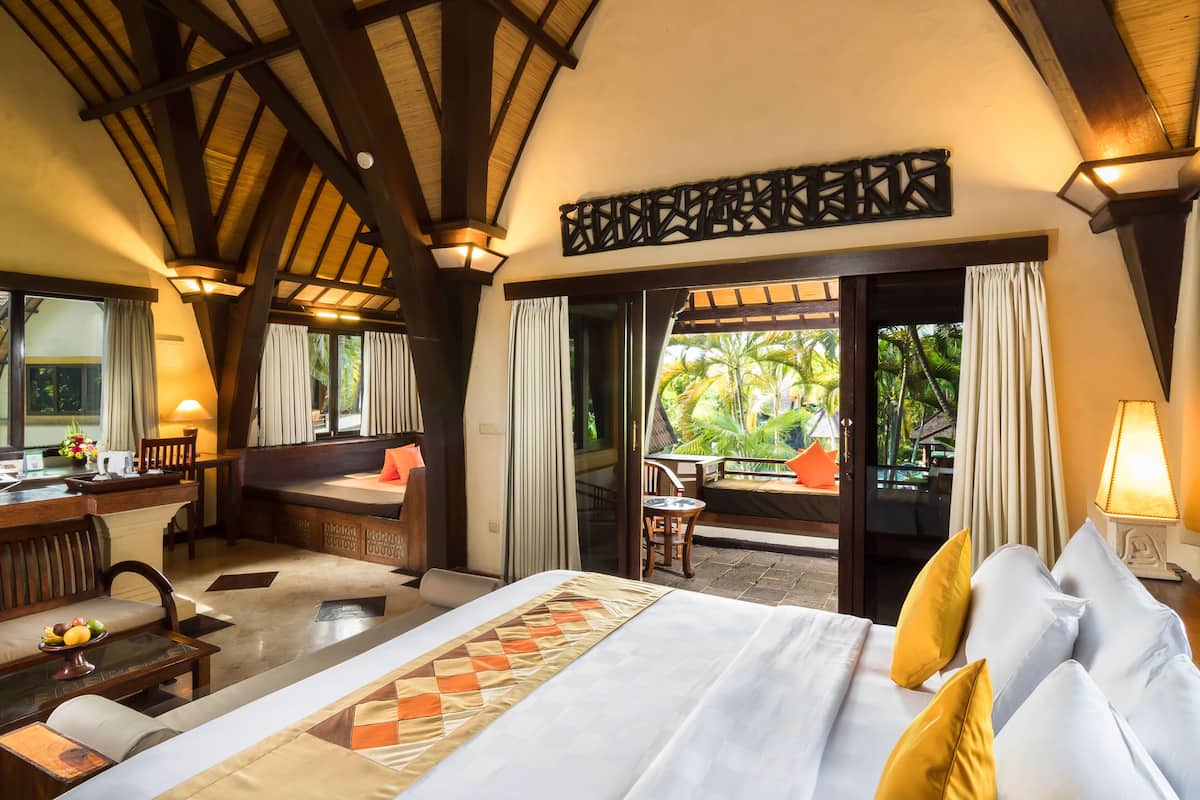 Une chambre d’hôtel avec un lit, un coin salon et une vue sur l’extérieur.