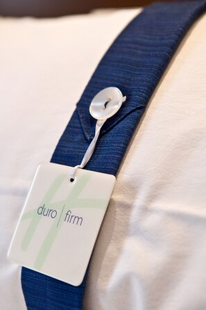 Una etiqueta adherida a un objeto azul de tela, posiblemente una prenda o accesorio, con el texto "duro firm" a la vista.