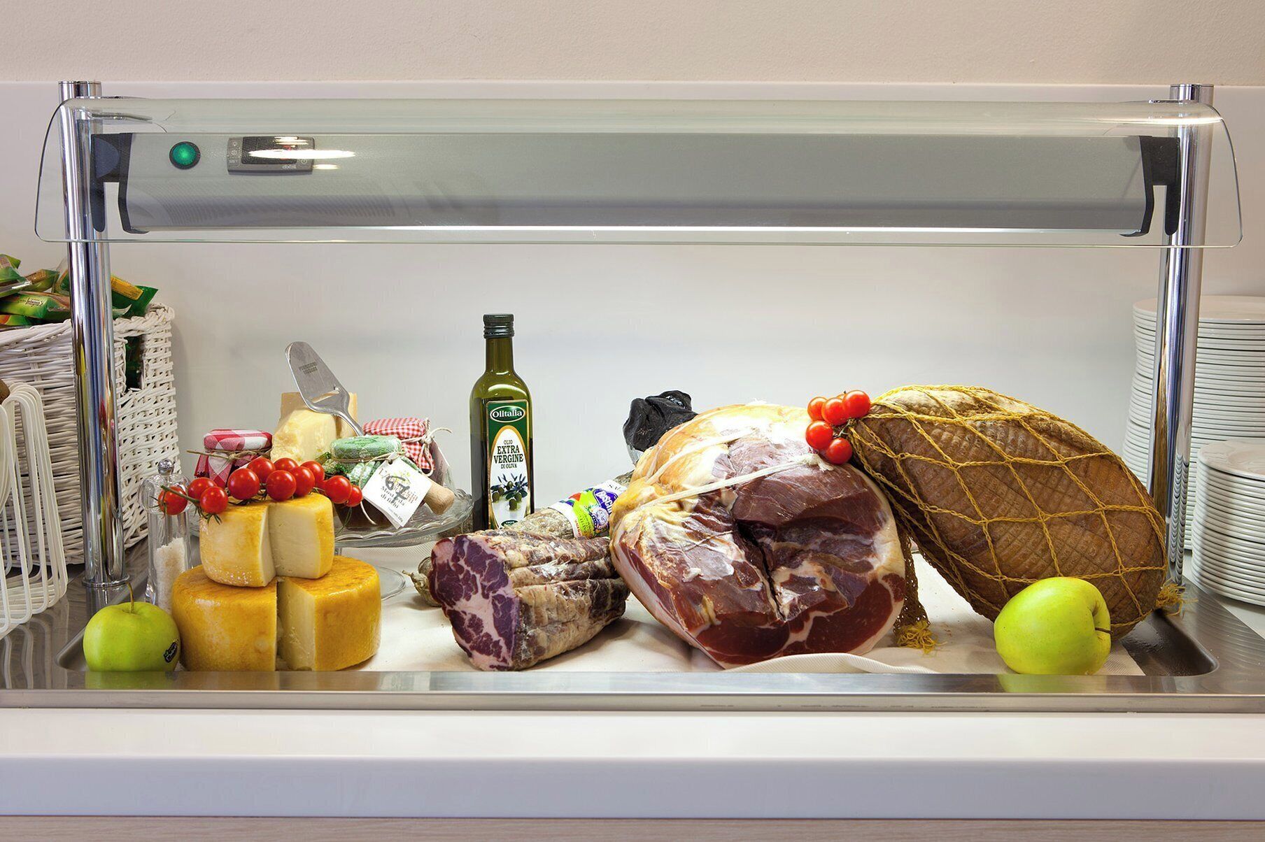 Un refrigerador lleno de diversos alimentos, incluyendo queso, carne y una botella de aceite de oliva.