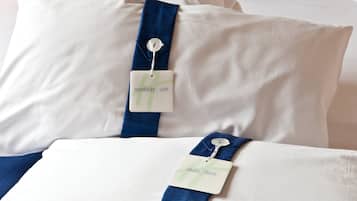 Una cama con dos almohadas, cada una con una etiqueta que indica los niveles de firmeza 'morbido' y 'firme'.