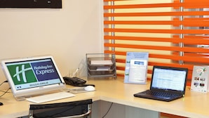 Un bureau avec un ordinateur, un téléphone et un ordinateur portable.