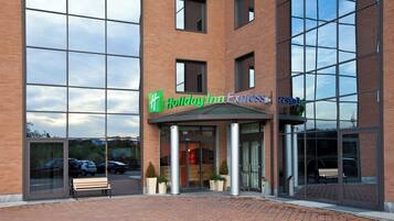Edificio Holiday Inn Express con fachada de ladrillo, ventanas grandes y un toldo verde.
