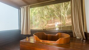 A wooden bathtub in a room with a large window overlooking a forest. - La Pedrera Small Hotel & Spa (Búzios)