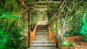 A stone staircase surrounded by lush greenery and a wooden pergola. - La Pedrera Small Hotel & Spa (Búzios)