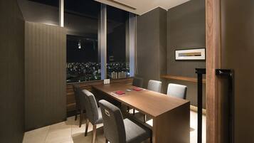 A conference room with a city view, large windows, and a long table with chairs.