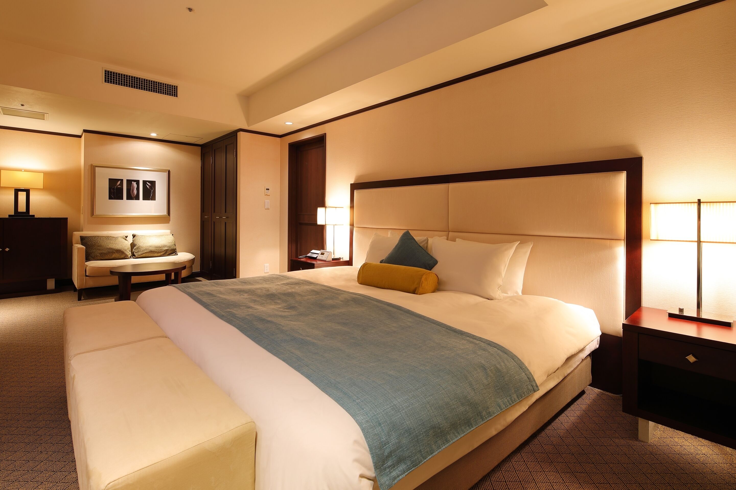 Una habitación de hotel con una cama grande, una mesita de noche, una silla y un escritorio.