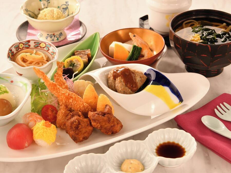 Variedad de platos japoneses en una bandeja, como sushi, tempura y otros aperitivos.