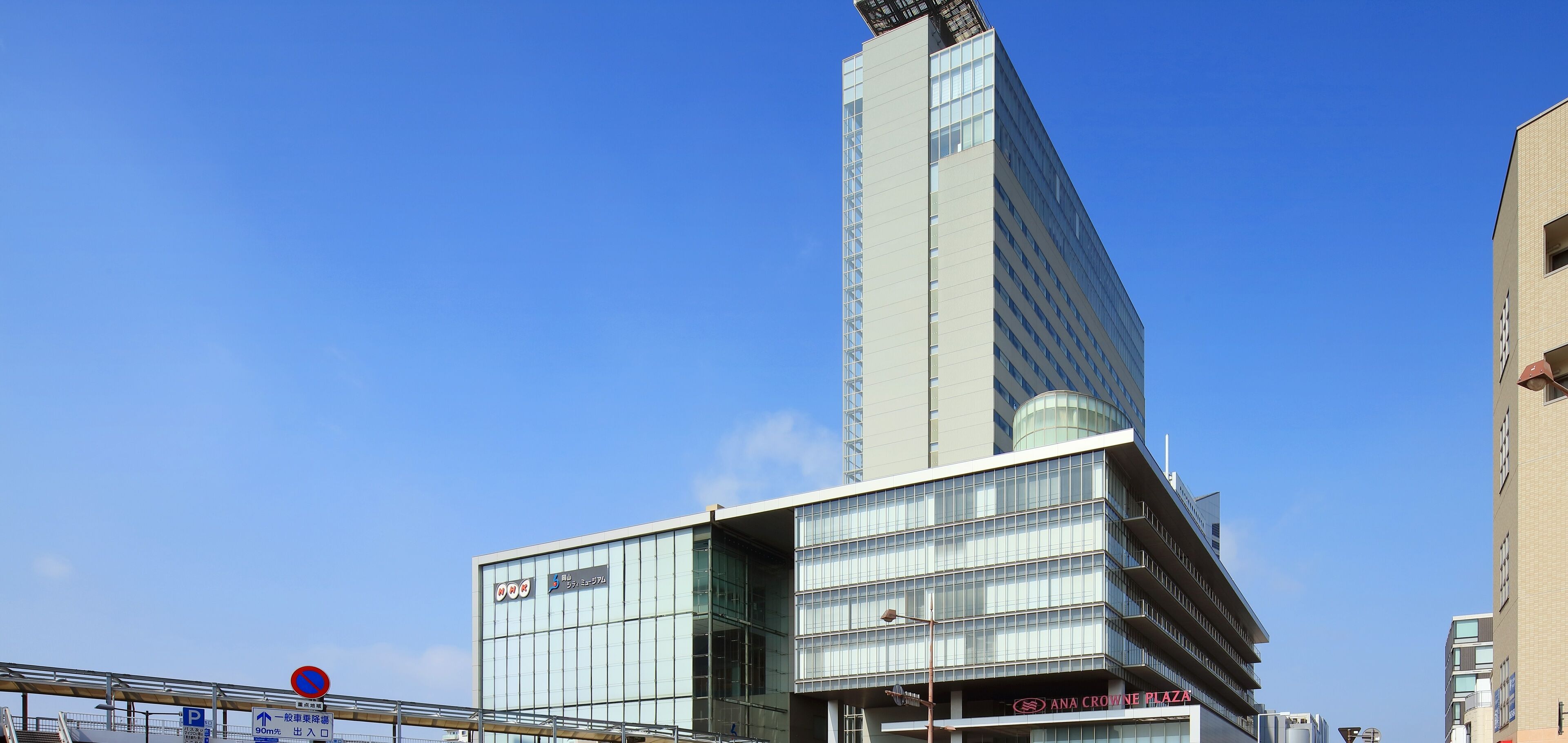 A modern building with a prominent glass facade and a unique angular design.