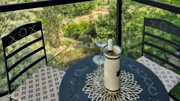 Un balcón con mesa y sillas, con vistas a un paisaje urbano.