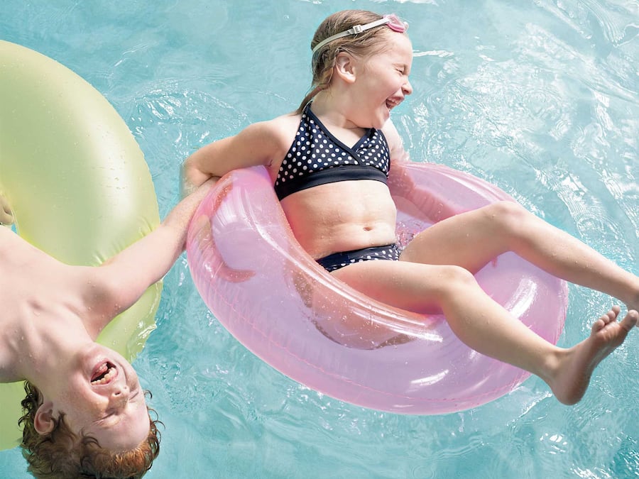 Una persona flota en un círculo rosa hinchable en una piscina.