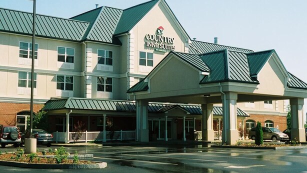 A Country Inn & Suites with a modern design, featuring a covered entrance and multiple windows. - Country Inn & Suites by Radisson, Brockton (Boston), MA (Brockton)