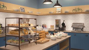 A bakery counter with various baked goods, a coffee machine, and a waffle maker.