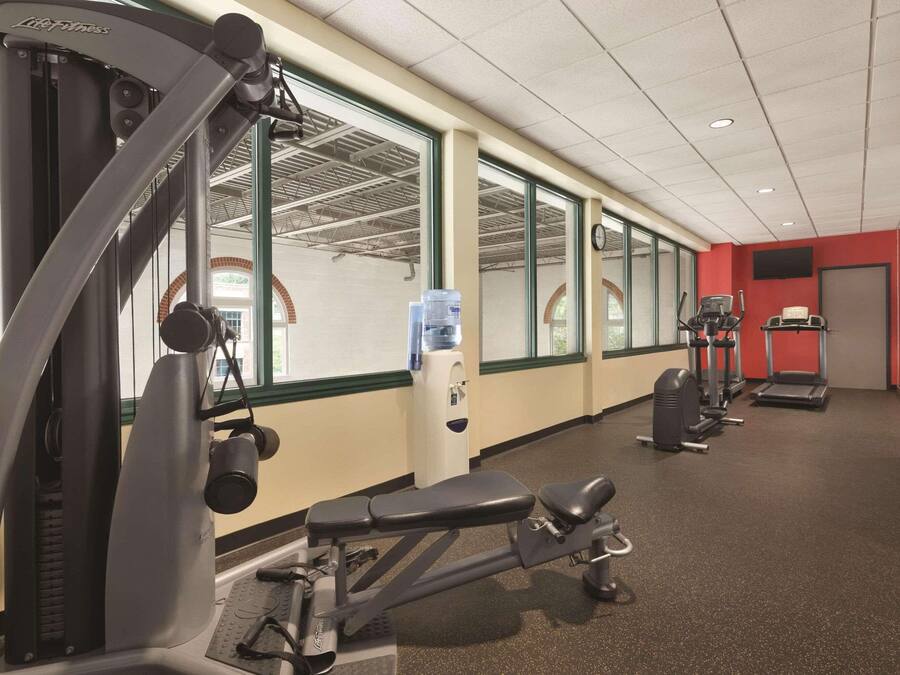 A gym with cardio machines, weight benches, and a water dispenser.